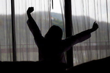 Silhouette of Young asian woman stretching in the morning