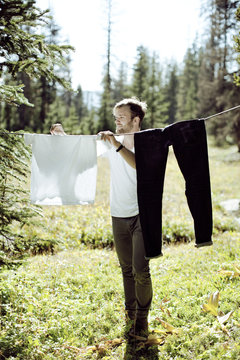 Man hanging laundry in meadow