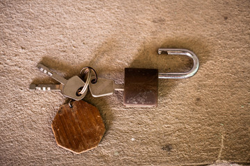 old rusty iron keys on cement background.