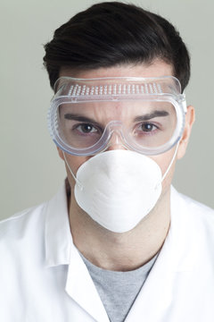 Portrait of a male Scientist in a laboratory coat wearing a protective face mask and goggles