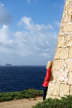 Malta, Young woman looking towards Fifla Island 