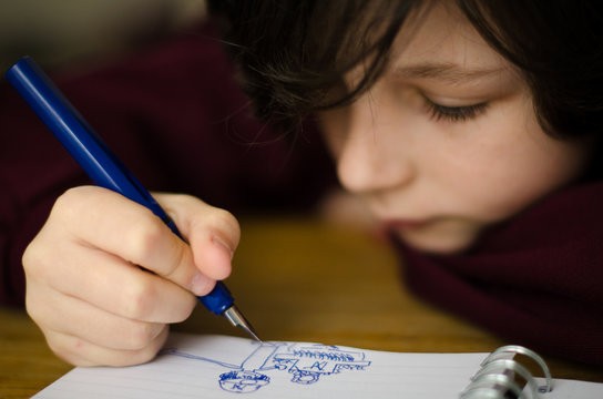Close up of boy drawing in book