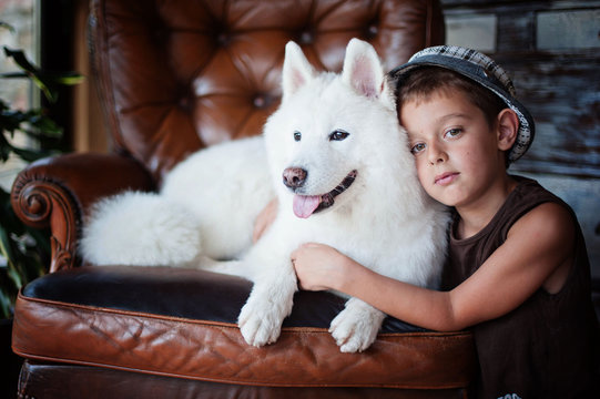 Portrait of boy (8-9) with samoyed dog
