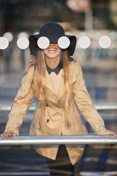 Smiling girl (12-13 )in hat seeing through bus stop