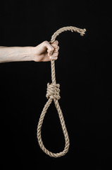 man's hand holding a loop of rope for hanging on  isolated