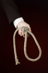 Hand of a businessman holding a loop of rope for hanging