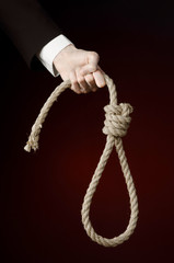 Hand of a businessman holding a loop of rope for hanging