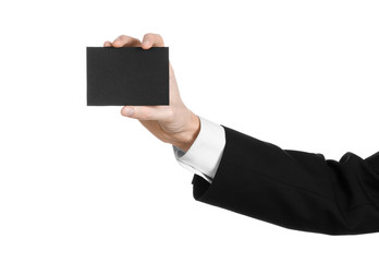 Man in black suit holding a black blank card in hand isolated