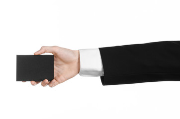 Man in black suit holding a black blank card in hand isolated