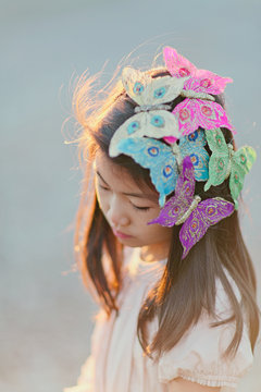 Girl (8-9) with butterflies on hair