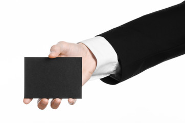 Man in black suit holding a black blank card in hand isolated