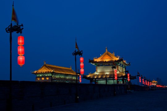 China, Shaanxi, Xian, Ancient city wall in front of traditional buildings at night