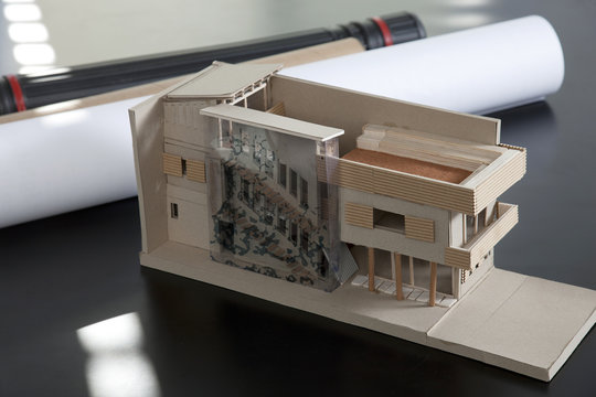 Close-up of an architectural model and rolled up architectural plans on a table in an office