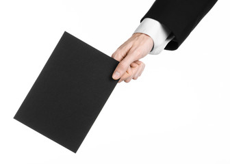 Man in black suit holding a black blank card in hand isolated