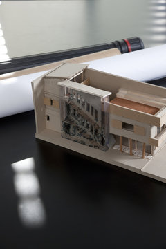 Close-up of an architectural model and rolled up architectural plans on a table in an office