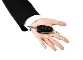 car salesman in a black suit holding a car key isolated