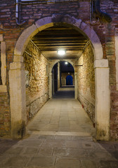 Fototapeta premium Przejście ciemnej alei w Wenecji w nocy