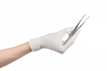 doctor's hand in a white glove holding tweezers isolated studio