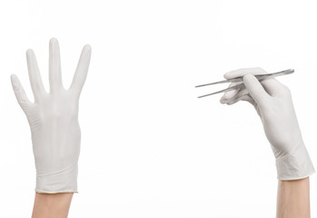 doctor's hand in a white glove holding tweezers isolated studio