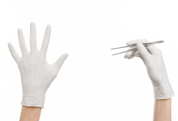 doctor's hand in a white glove holding tweezers isolated studio