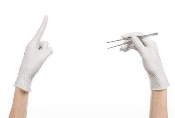 doctor's hand in a white glove holding tweezers isolated studio