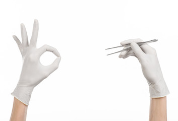 doctor's hand in a white glove holding tweezers isolated studio
