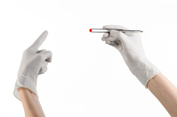 doctor's hand holding tweezers with red pill capsule isolated