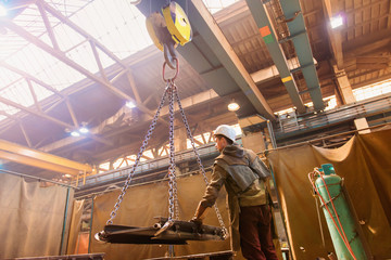 Young man in a factory preparing equipment for welding.