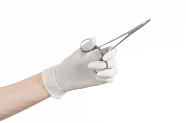 doctor's hand in a white glove holding a surgical clip isolated