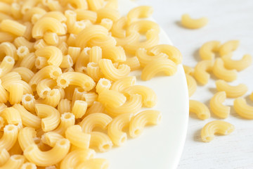 Closeup of dry macaroni pasta on white dish