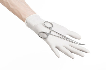 doctor's hand in a white glove holding a surgical clip isolated