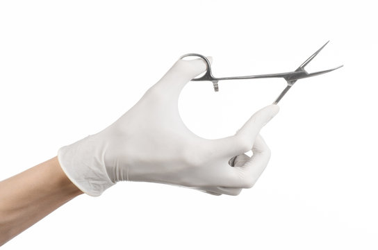 doctor's hand in a white glove holding a surgical clip isolated