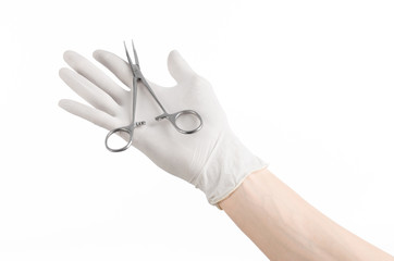 doctor's hand in white glove holding a surgical clamp with swab