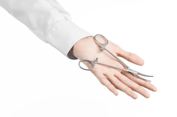 doctor's hand holding a surgical clamp scissors in studio