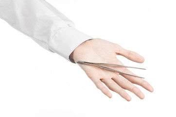 a doctor's hand holding tweezers isolated on white background