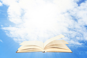 Opened book on sky background
