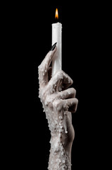 hands holding a candle, a candle is lit, black background