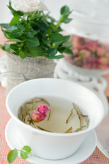 Cup of healthy green tea with dried roses