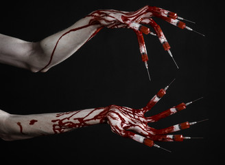 Bloody hand with syringe on the fingers, toes syringes in studio