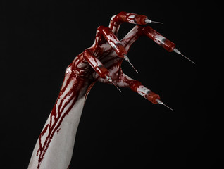 Bloody hand with syringe on the fingers, toes syringes in studio