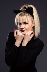 young beautiful woman dressed as cuddly cat makes gestures