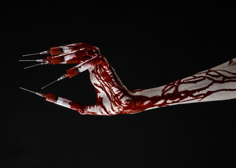 Obraz na płótnie Canvas Bloody hand with syringe on the fingers, toes syringes in studio