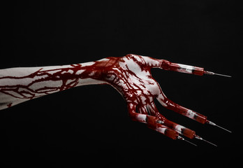 Bloody hand with syringe on the fingers, toes syringes in studio