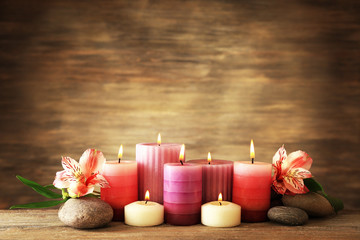 Beautiful composition with candles and spa stones on wooden background