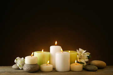 Fototapeta na wymiar Beautiful composition with candles and spa stones on dark background