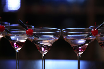 Glasses of cocktails on bar background
