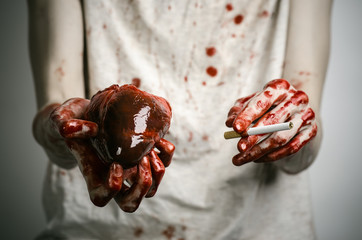 bloody hand holding a cigarette smoker and bloody human heart