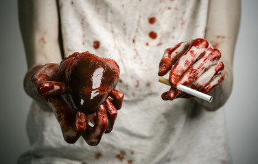 bloody hand holding a cigarette smoker and bloody human heart - 83552602