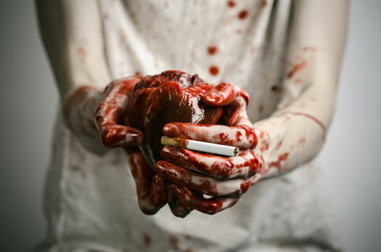 bloody hand holding a cigarette smoker and bloody human heart