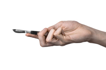 The hand holding the scalpel, white background, isolated studio